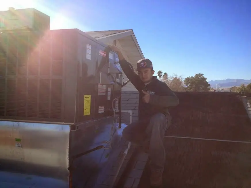 HVAC technician performing Air Duct Repair on a rooftop unit in Ira